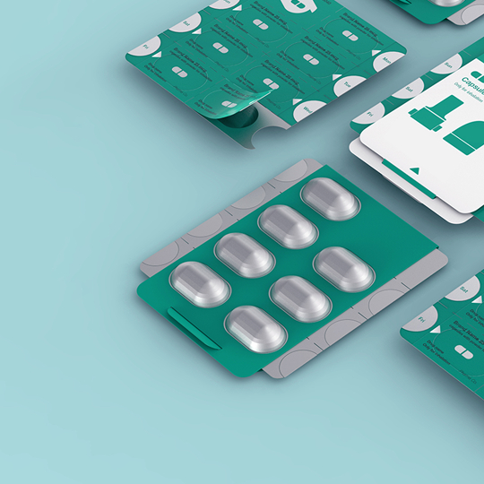 Blister pack of capsules. Teal packaging, silver capsules. Pharmaceutical product design.