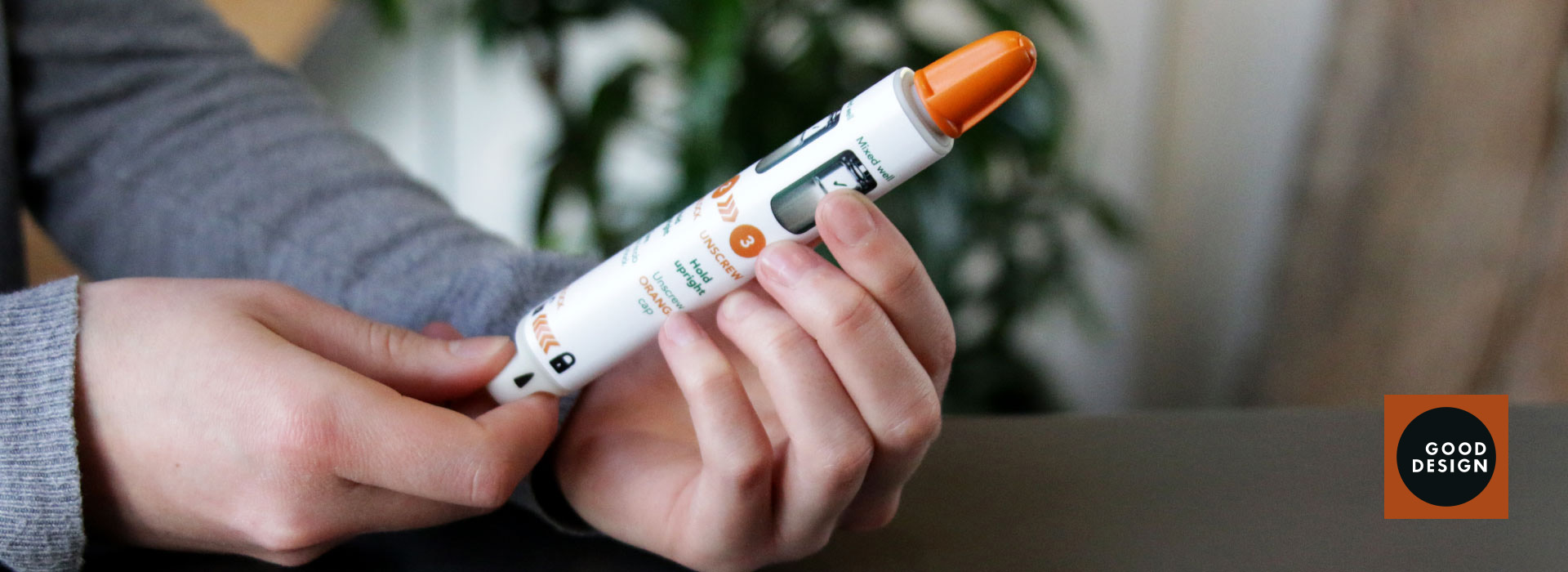 hands-holding-trainer-auto-injector-pen-with-logo-2
